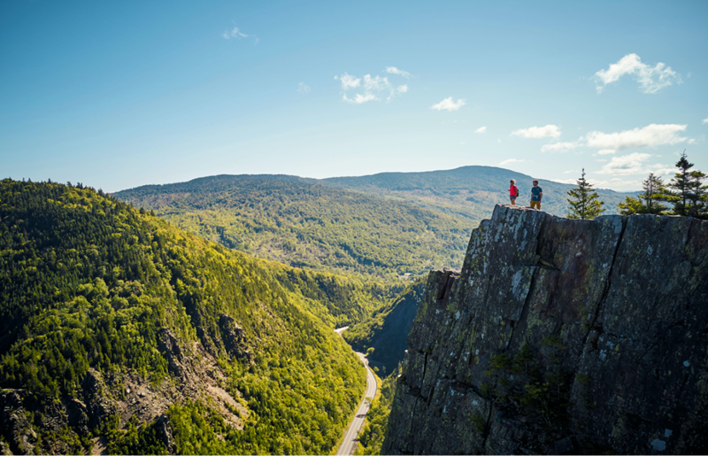 Hikers standing at an overlook on a cliff