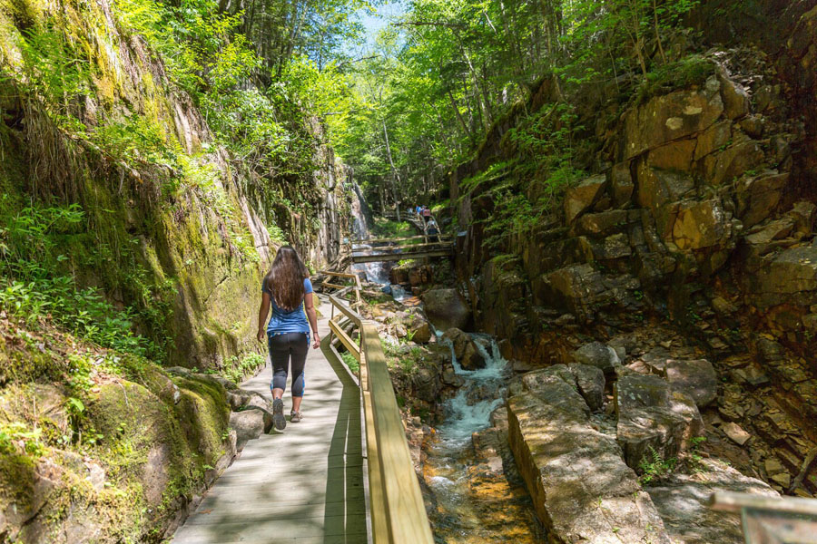 Woman walking down a boardwalk next to waterfalls