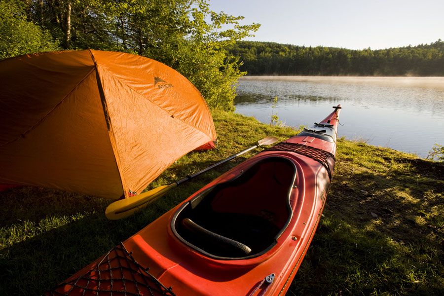 Kayak and tent by the lake