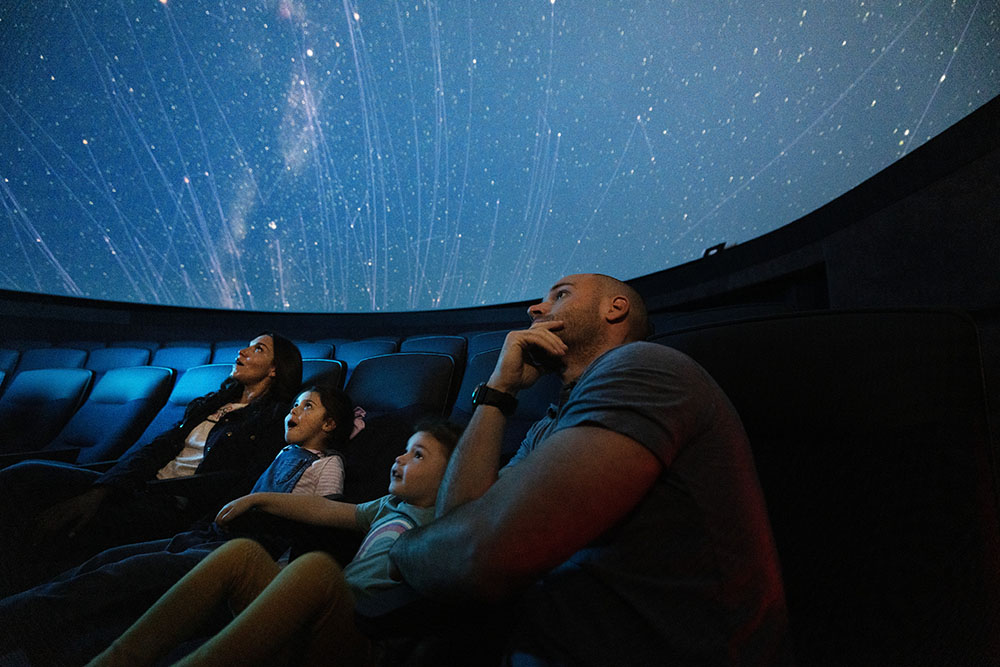 Family sitting in a planetarium 