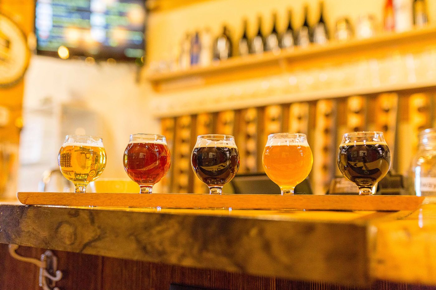 flight of beer sitting on a bar with a blurred background