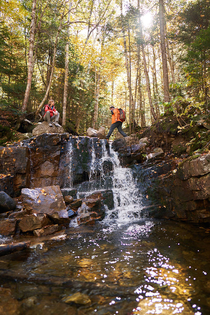 People hiking by a waterfall