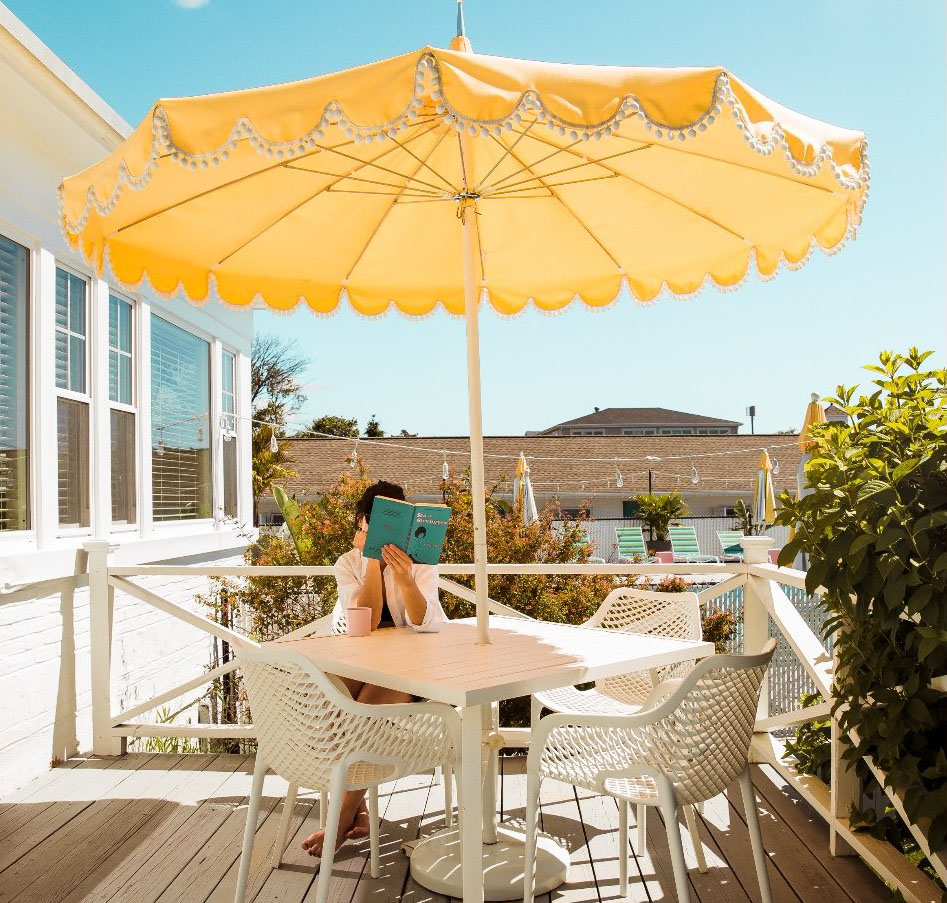 a table and umbrella on a patio overlooking a pool