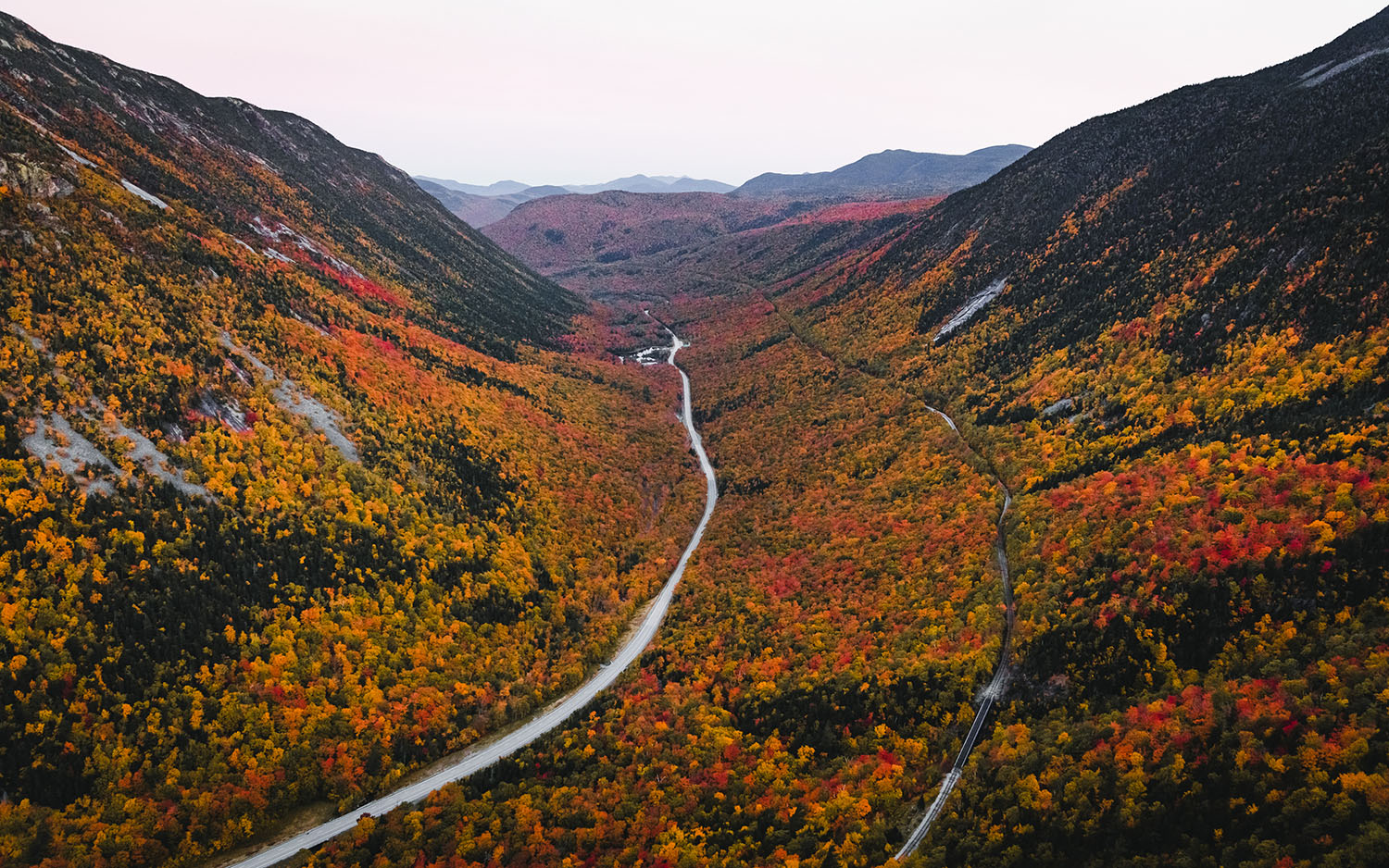 aerial view overlooking road through mountains