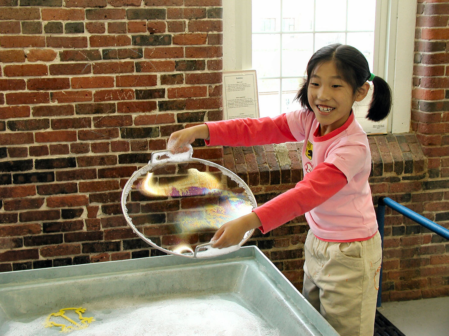 child playing with bubbles indoors