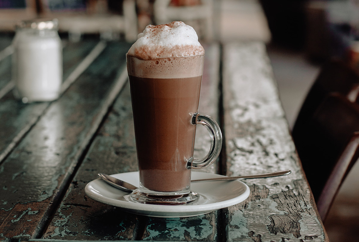 hot chocolate with foam sitting on bar top