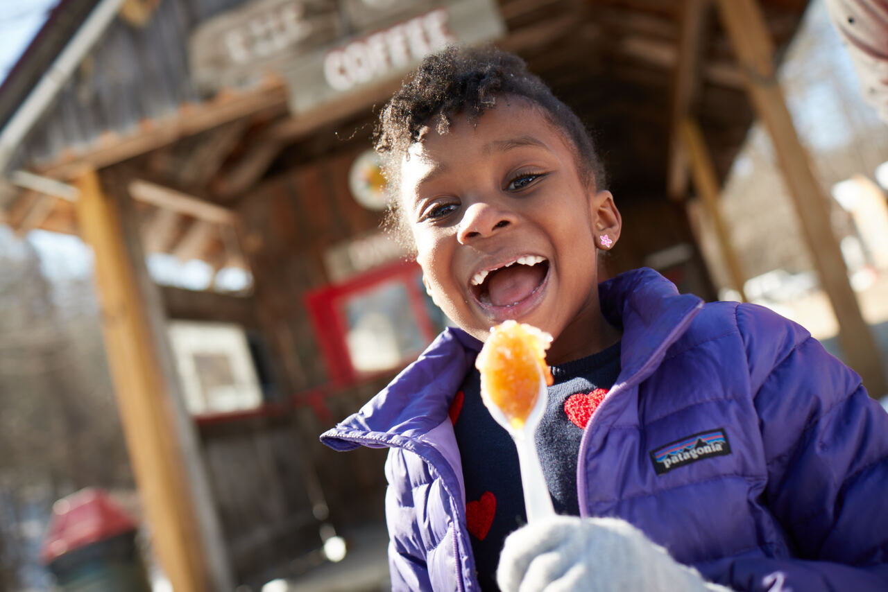 little girl eating syrup