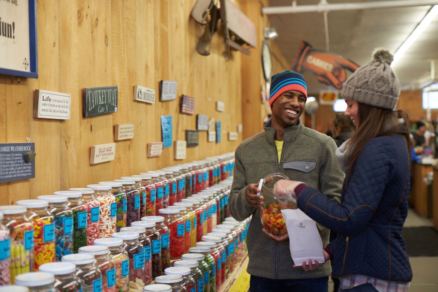 Happy couple in candy store putting candy in a bag