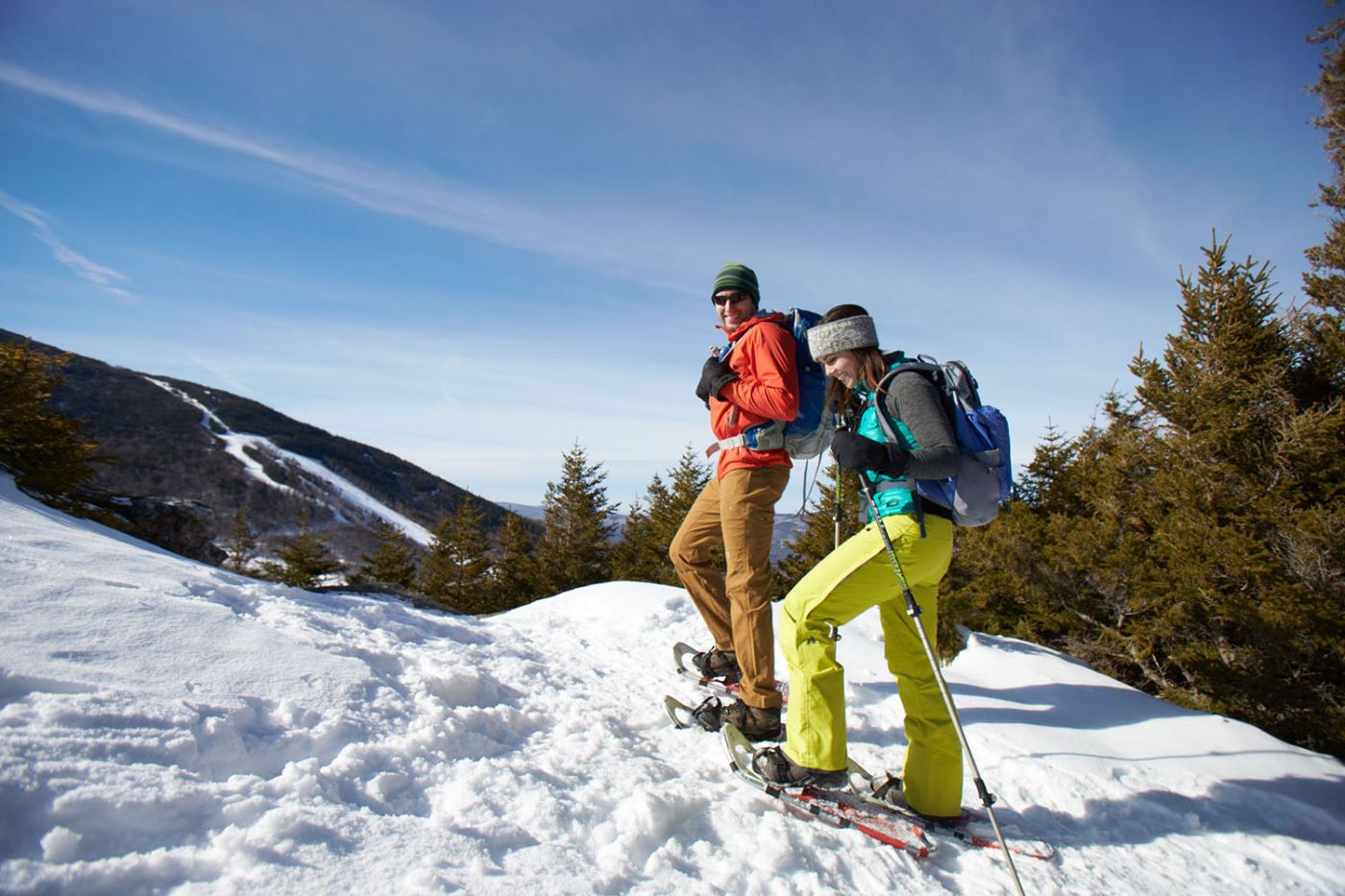 couple hiking a snowy mountain on a sunny winter day