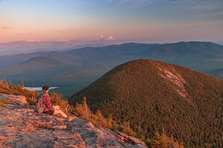 person sitting at the top of a mountain