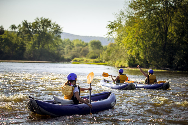 Two people white water rafting on a river