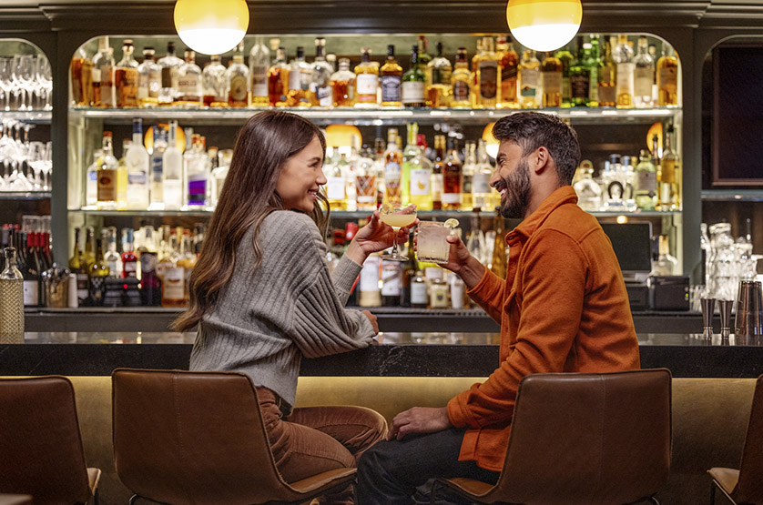 A couple enjoying cocktails at a bar