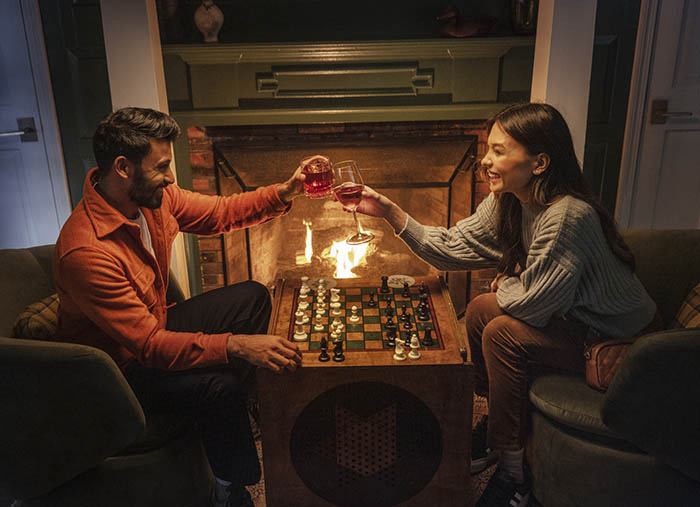 two people playing a game by a fire in an inn